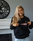 Woman showing zip function of a breastfeeding crew sweatshirt