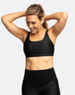 Active mom wearing black matching breastfeeding sports bra and maternity leggings