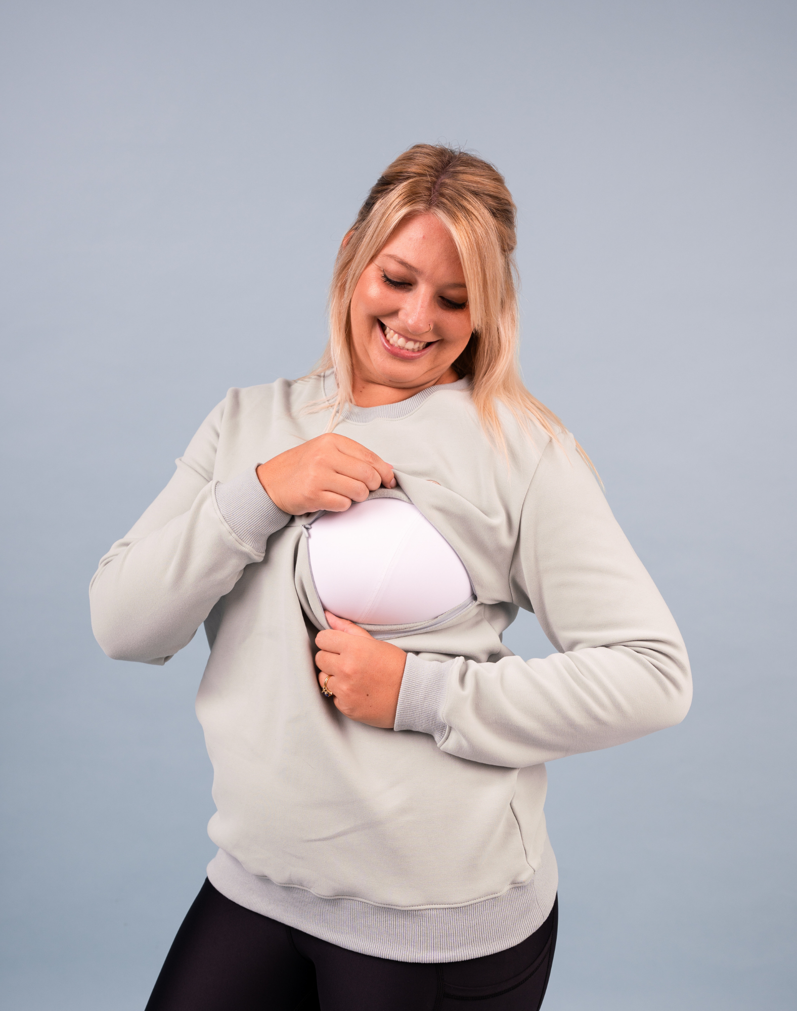 mother showing the easy zip nursing function of a nursing sweatshirt