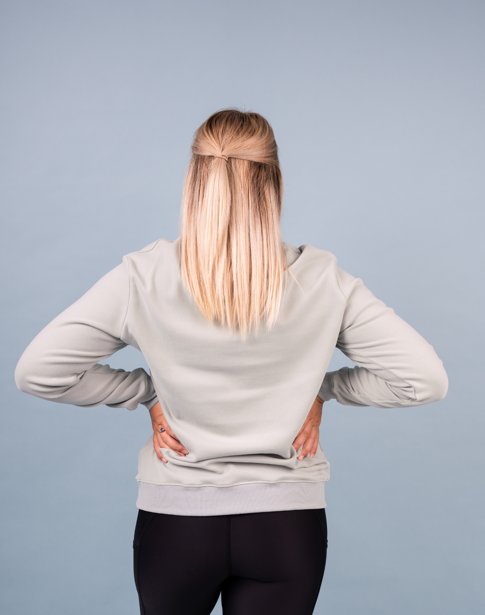 Back view of active mum wearing pale green coloured maternity sweatshirt 