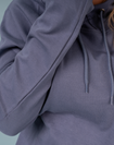 back view of woman wearing light blue jumper, showcasing contract print trim in the hood