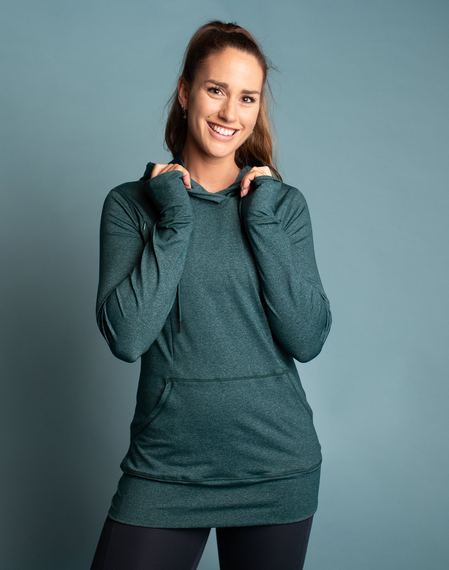 Fit mum wearing a breastfeeding hoodie in emerald green