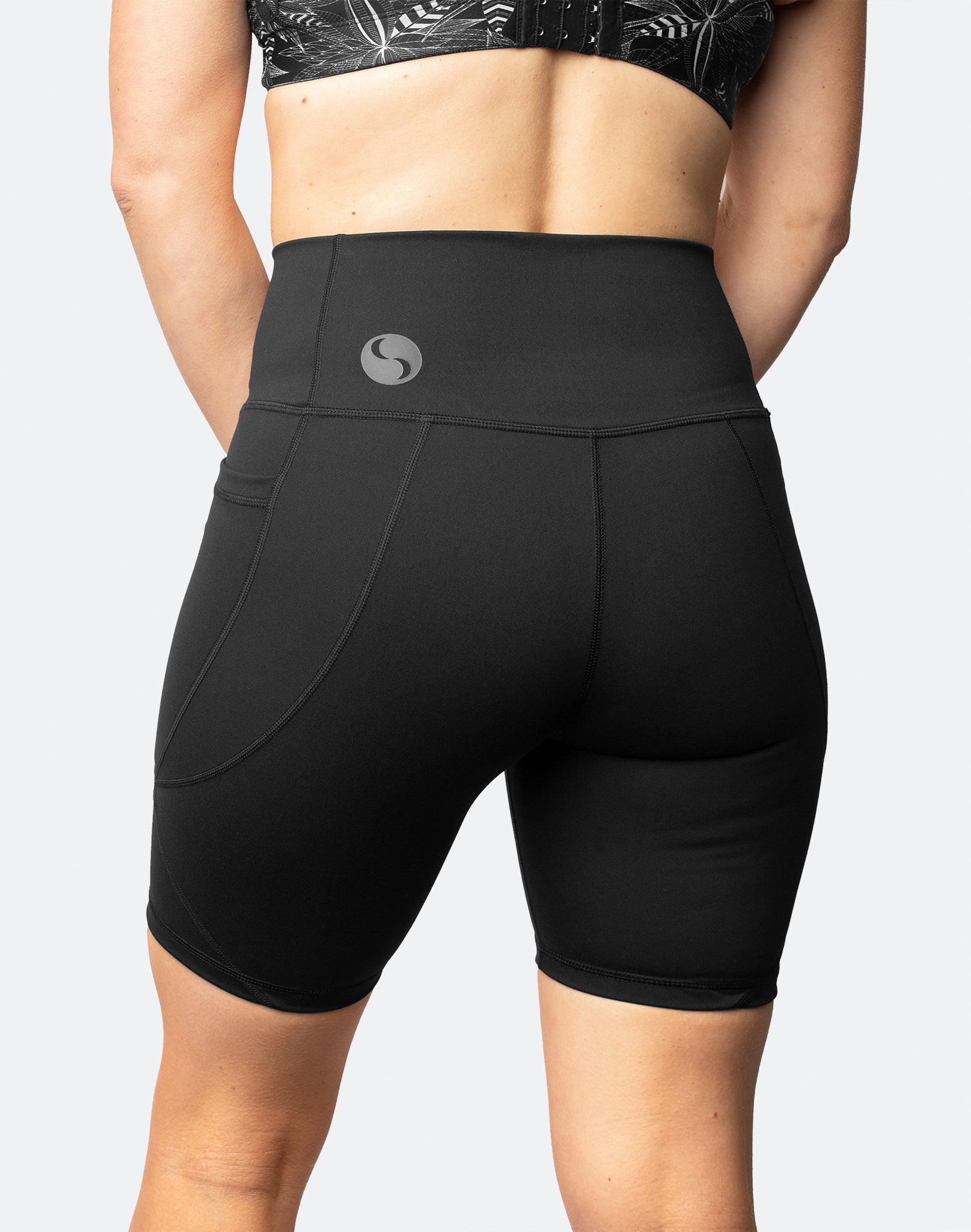 Back view of active mother wearing high waisted postpartum bike shorts