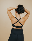 Back view of active mom wearing black nursing sports bra