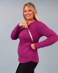 Active mum wearing a magenta nursing long sleeve top