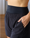 side view of mom wearing mid-waisted maternity and postpartum shorts in black 