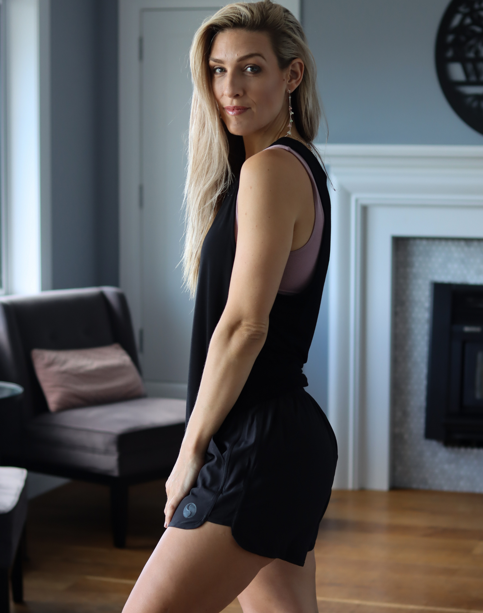 side view of mum wearing mid-waisted maternity and postpartum shorts in black 