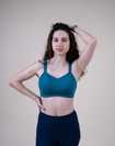 Happy active mother wearing supportive breastfeeding bra in the colour teal