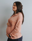 Side view of expecting mother wearing pink nursing hoodie
