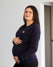 Pregnant mother wearing maternity breastfeeding navy crew neck jumper